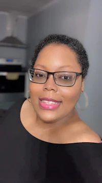 a woman wearing glasses and a black top