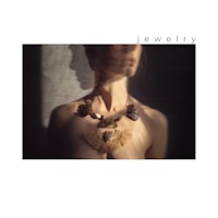 an image of a woman wearing a necklace with feathers