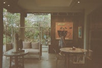 a woman standing in a room with a table and chairs