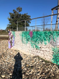 a person is standing next to a wall with graffiti on it