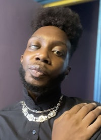 a man with an afro wearing a necklace