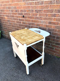 a white serving cart with a wooden top