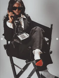 a woman sitting in a chair and talking on the phone