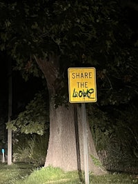 a street sign on the side of a tree