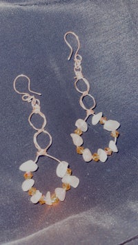 a pair of earrings with white and yellow stones