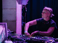 a woman djing in front of a purple screen