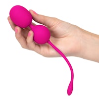 a woman's hand holding a pink sex toy