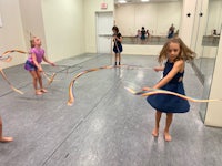 a group of girls playing with hula hoops in a dance studio