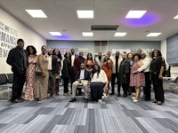 a group of people posing for a photo in an office