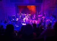 a group of people watching a band perform in a dark room