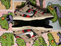 a pair of nike sb dunk low sneakers on a carpet