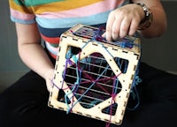 a woman is holding a wooden box with yarn in it