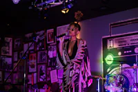 a woman in a dress singing into a microphone