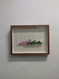 a framed piece of paper with a pink flower on it
