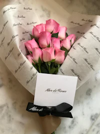 a bouquet of pink roses wrapped in paper