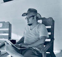 a man in a cowboy hat using a laptop