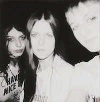 three girls are posing for a photo in a dark room