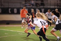a group of girls playing football on a field