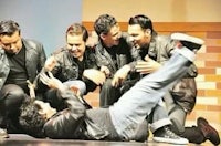 a group of men laying on the ground on a stage