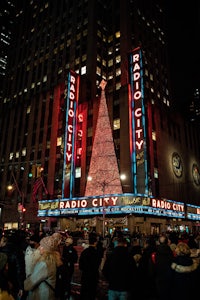 a large christmas tree in front of a radio city building
