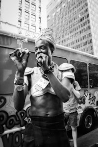 a man in a costume smoking a cigarette in front of a bus