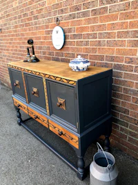 a painted wooden sideboard with a clock on it