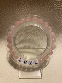 a pink bracelet with the word love on it