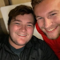 two men posing for a selfie in a hotel room