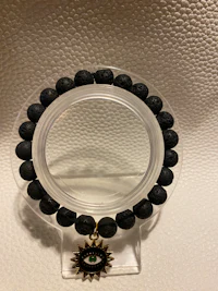 a black lava stone bracelet on a white surface