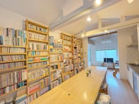 a kitchen with a lot of bookshelves and a wooden table