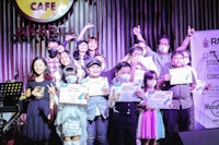 a group of people holding certificates in front of a stage