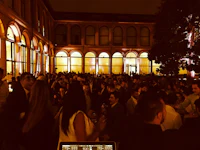 a group of people standing in front of a building at night