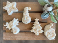 four christmas soaps on a wooden tray