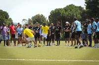 a group of people standing around a soccer field