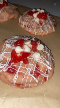 three cookies with white icing and red sprinkles