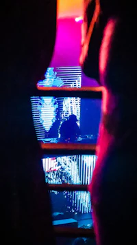 an image of a person in a dark room with neon lights