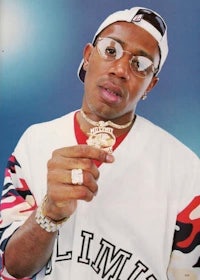 a man wearing glasses and a baseball cap holding a medal