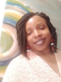 a woman smiling in front of a painting