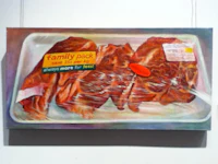 a painting of meat on a tray hanging on a wall