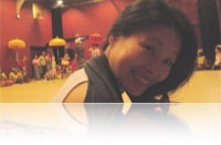 a woman smiles while sitting on a floor in a gym