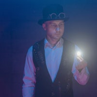 a man in a top hat holding a light bulb
