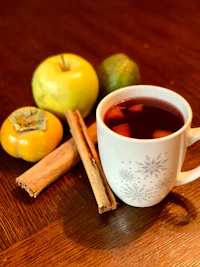 a cup of mulled wine with cinnamon sticks and apples