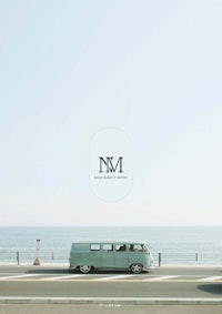 a vw bus driving down the road next to the ocean