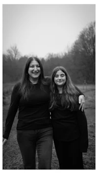 a black and white photo of two women standing in a field