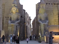 egyptian sphinxes and statues in front of a temple