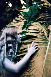 a woman is hugging a large leaf