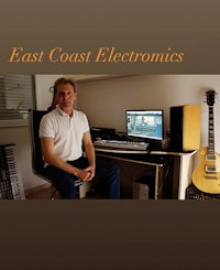 a man sitting in front of a computer with the words east coast electronics
