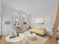 a living room with a yellow couch and white walls