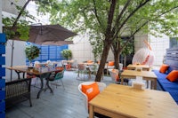 a blue and orange patio with tables and chairs