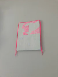a pink and white pouch hanging on a wall